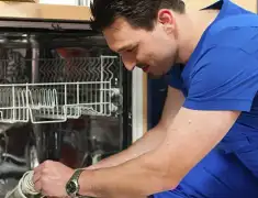 Dishwasher repair technician inspecting and servicing an open dishwasher in Denver, CO