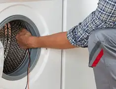 Dryer repair technician diagnosing and servicing a clothes dryer in Denver, CO