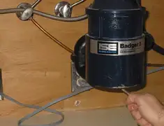 Garbage disposal repair technician tightening the mounting ring under a sink in Denver, CO