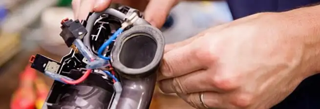 Vacuum repair technician reconnecting wiring and components in Denver, CO