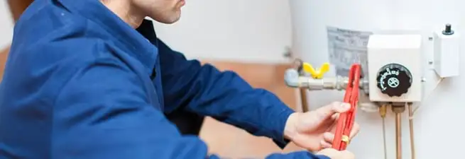 Water heater repair technician adjusting the temperature control and gas valve in Denver, CO